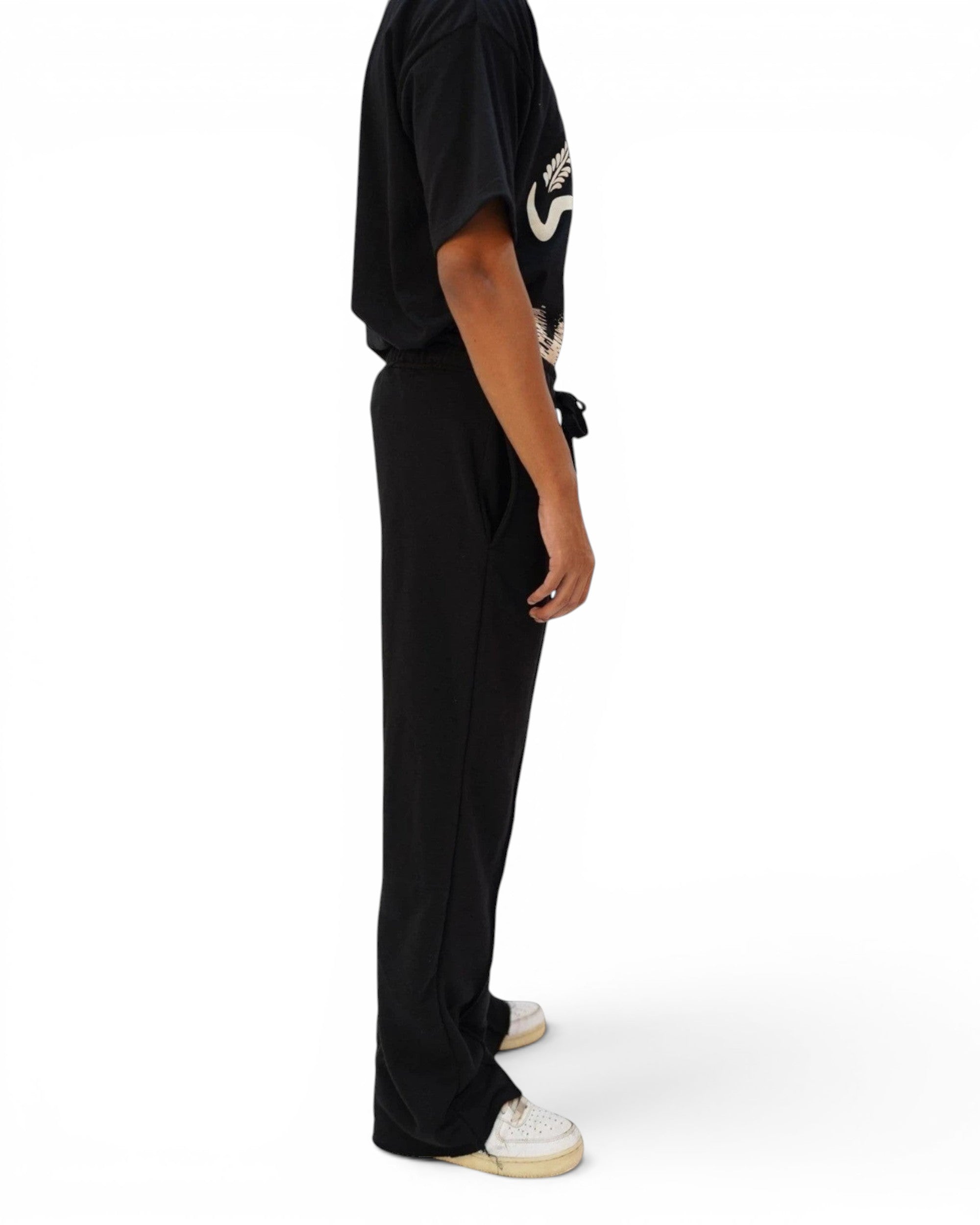Thrive black pleated flared trousers in terry fabric with drawstring waist, side view on a male model.